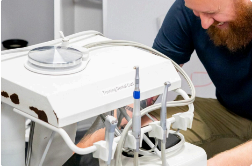 Smiling person happy to fix a training dental cart veterinary equipment.